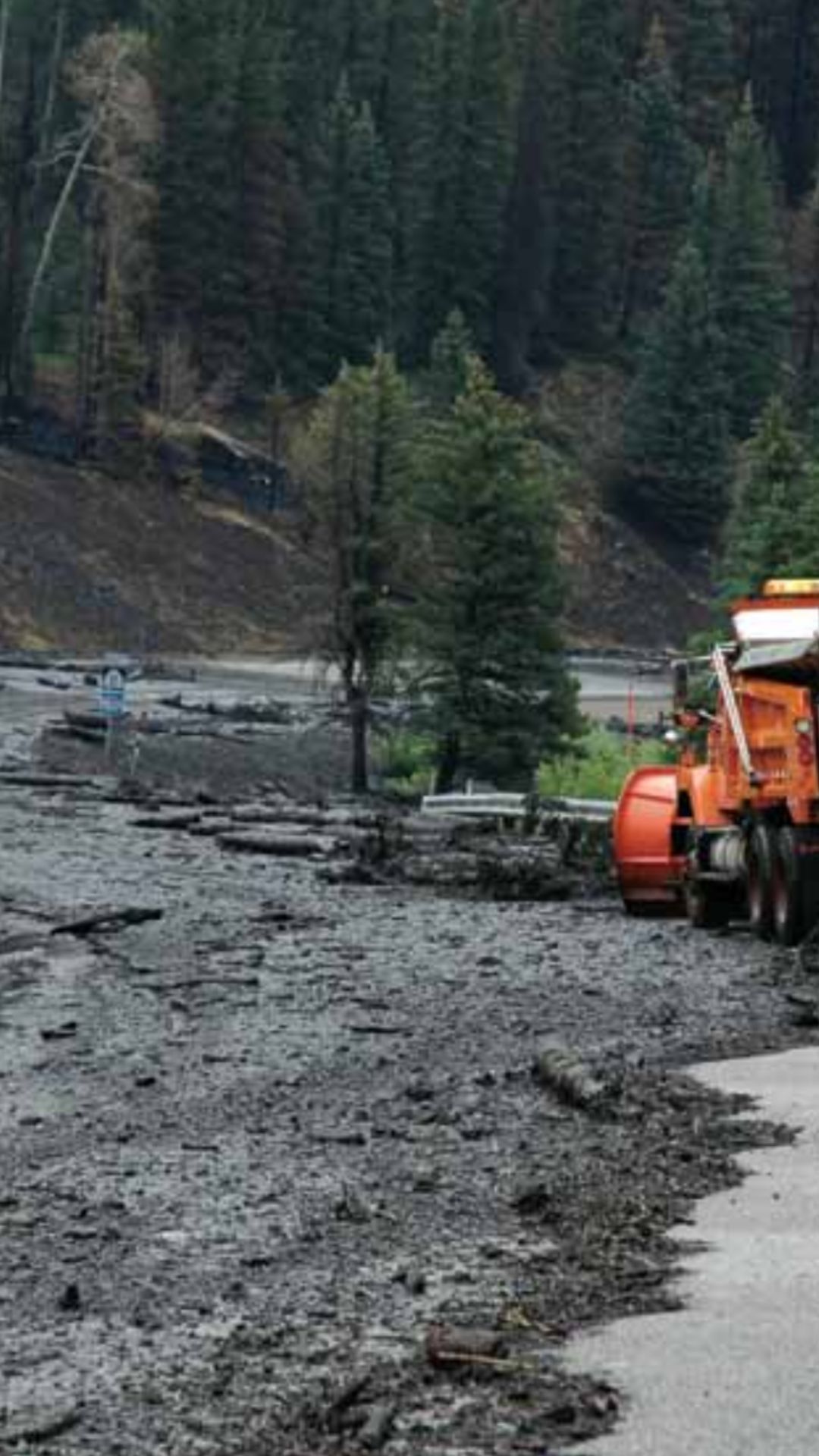 UDOT snowplow pushes mud off of a mountain road.